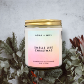 8 ounce jar soy wax candle Smells Like Christmas on background of Christmas Greenery